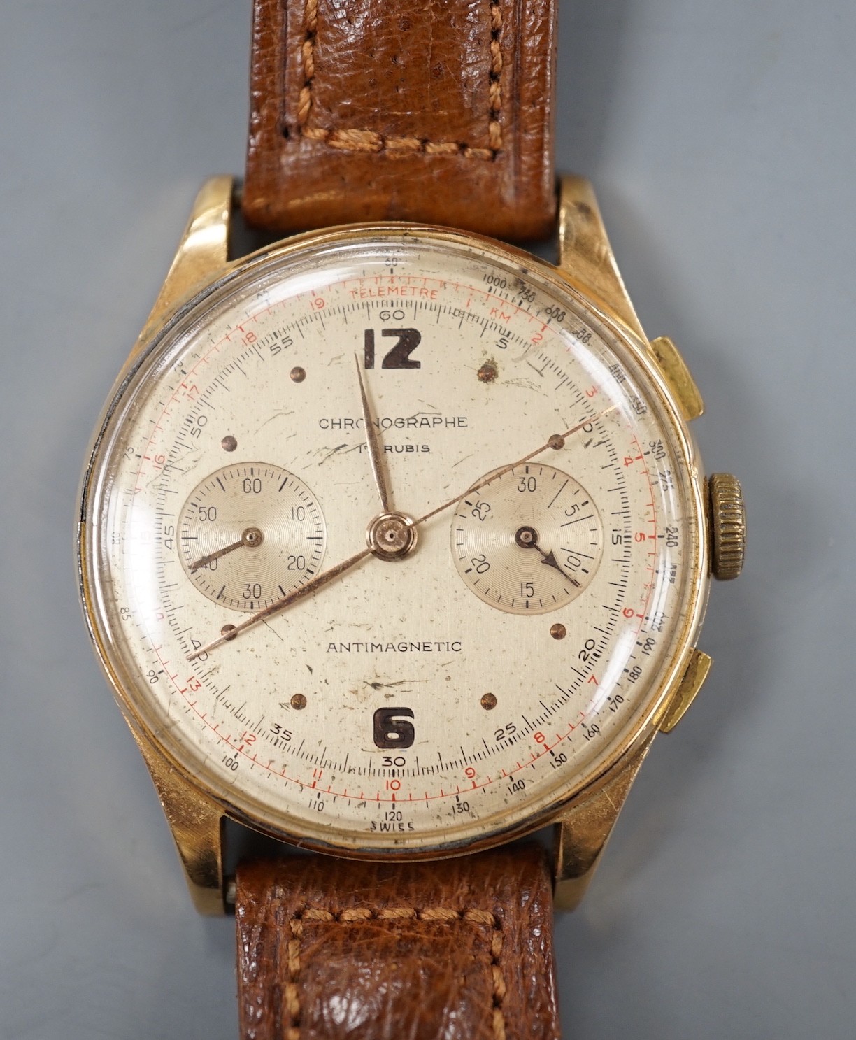 A 1940/1950's? Swiss 18k chronograph wrist watch, with two subsidiary dials, on a brown leather strap, case diameter 37mm, gross weight 45.5 grams.